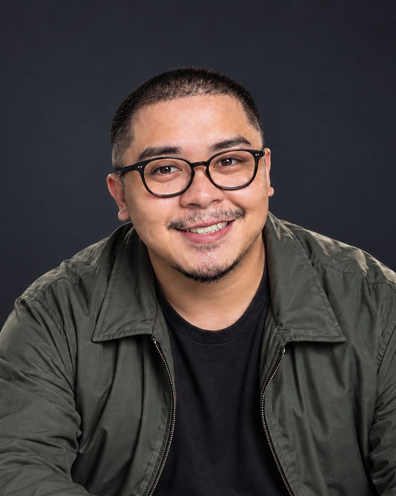 Rodel Luneta, founder of RampUp Studio Philippines, smiling in an olive jacket and glasses
